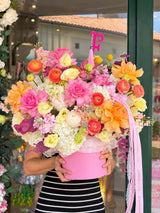 Grand luxury flower box with hot pink roses, orange ranunculus and peach garden roses in pink hatbox - Fashion Flowers Miami