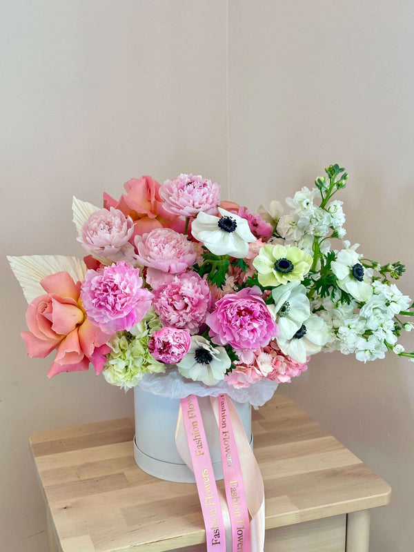 Beso de peonías: caja con peonías rosas, rosas, hortensias, anémonas y flores comunes.