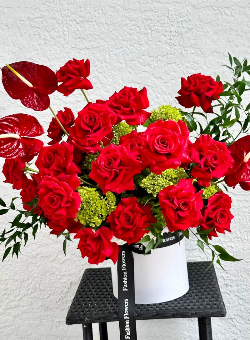 Beije-me - rosas vermelhas, hortênsias verdes, ruscus italiano e antúrio em uma caixa de flores
