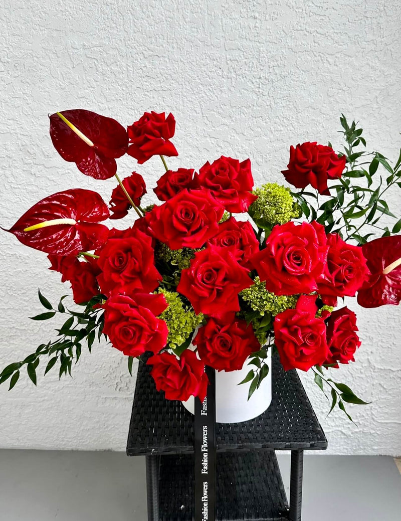 Beije-me - rosas vermelhas, hortênsias verdes, ruscus italiano e antúrio em uma caixa de flores