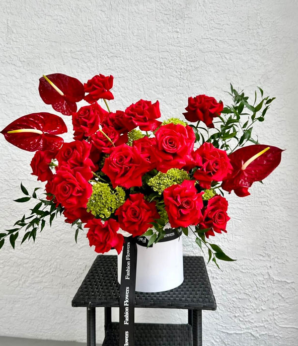 Bésame: rosas rojas, hortensias verdes, ruscus italiano y anturio en una caja de flores