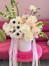 Elegant white flower arrangement with roses, anemones, ranunculus and Fashion Flowers ribbons in white hatbox - same-day delivery Aventura